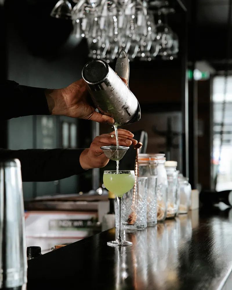 Green cocktail being poured at the Times of India bar
