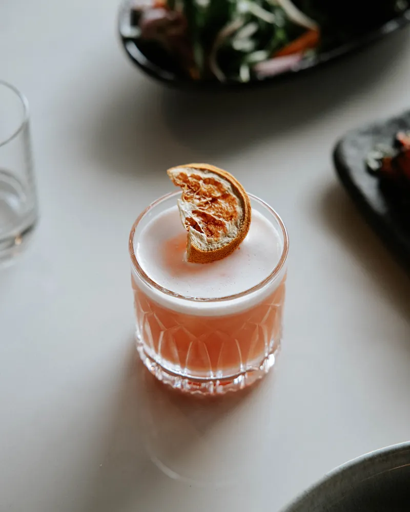 Orange bespoke cocktail served over ice at Times of India